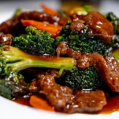 Grilled meat with sauce and green vegetables on the side