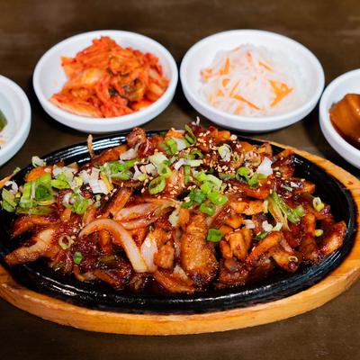 Spicy pork belly with assorted sides.