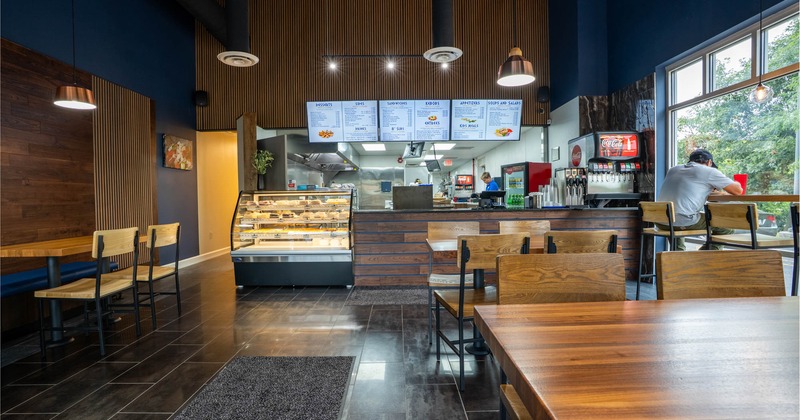 Interior, dining area, checkout counter and kitchen in the back, refrigerated display case