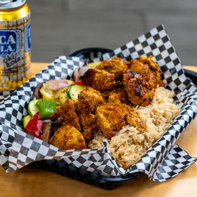 Seasoned grilled chicken with rice and vegetables.