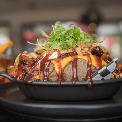 Jumbo baked potato, with BBQ brisket, nacho cheese, sour cream, and fried onion.