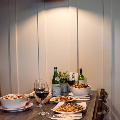 A dining table with served food and wine.