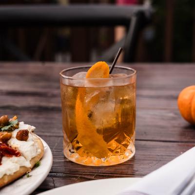 Old Fashioned cocktail with orange peel garnish.