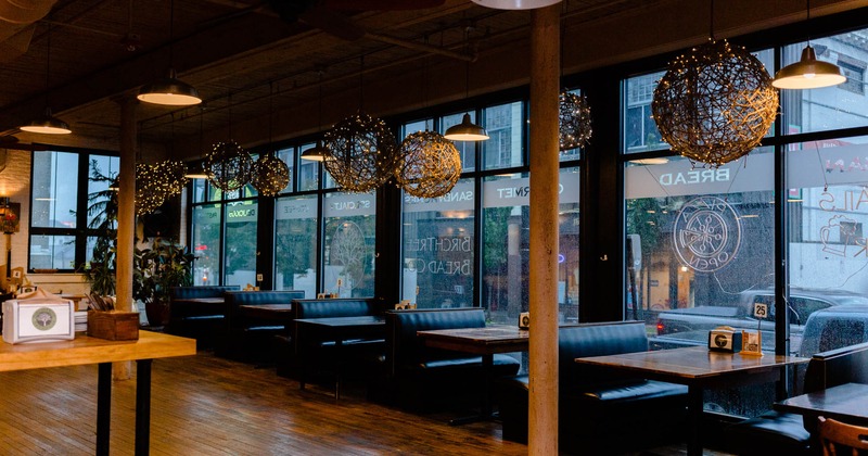 Interior, booth seating and tables by a window side, hanging twine ball light