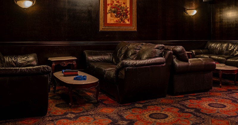 Interior, comfortable three seater sofas with low coffee tables, carpet flooring, paintings