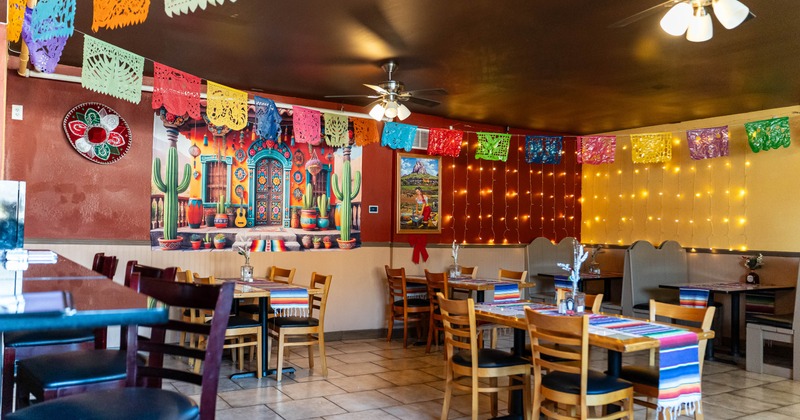 Interior seating area with chairs, tables, double booths and colorful decorations