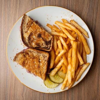 Reuben sandwich on rye,  served with fries, top view.