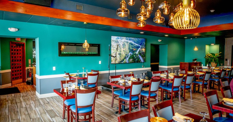 Interior, dining area, tables ready for guests, tile flooring, large screen TV