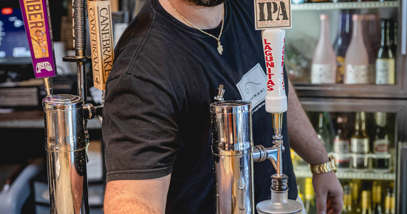 Bartender serves a glass of beer behind bar counter