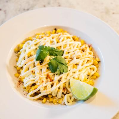 Whole kernel corn in cotija cheese and powder chili topped with mayo.