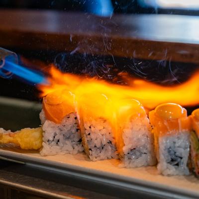 Salmon sushi rolls being torched.