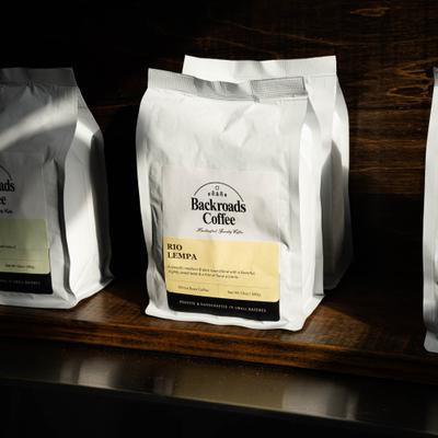 Coffee bags on a wooden shelf.