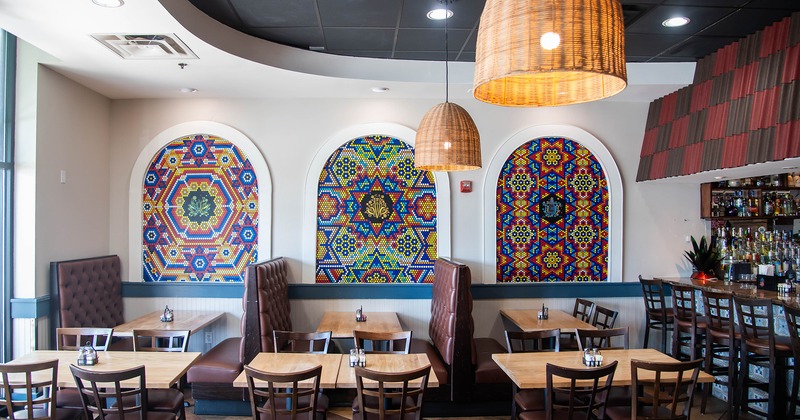 Cozy interior dining area, tables, chairs, and upholstered booths