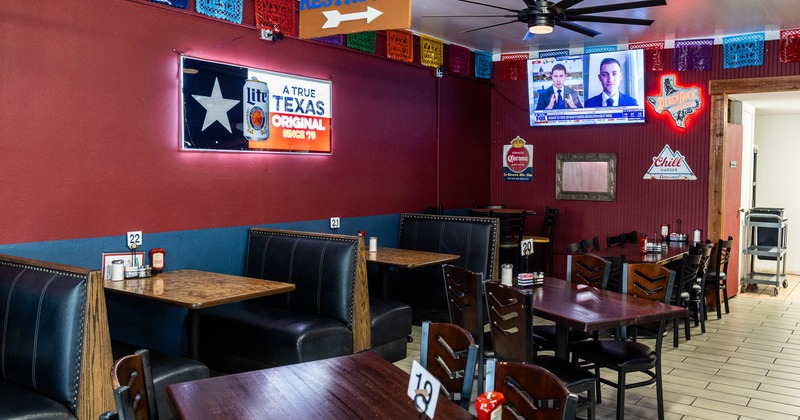 A cozy diner interior with wooden tables, dark booths
