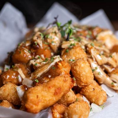 Tater tots, with pulled chicken, gravy, and onions.