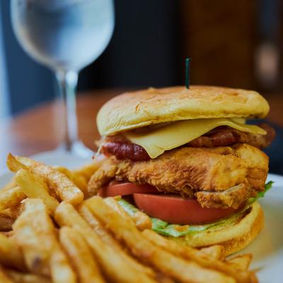 Fried chicken sandwich, with BLT, Swiss cheese, mayo, and a side of fries.