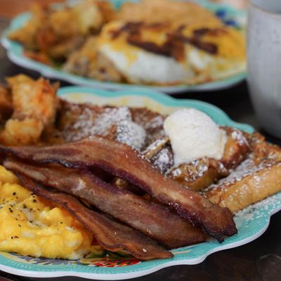 Scrambled eggs served with crispy bacon and French toast.