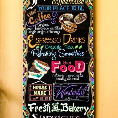 Chalkboard menu for a cafe offering a variety of refreshments and food items.