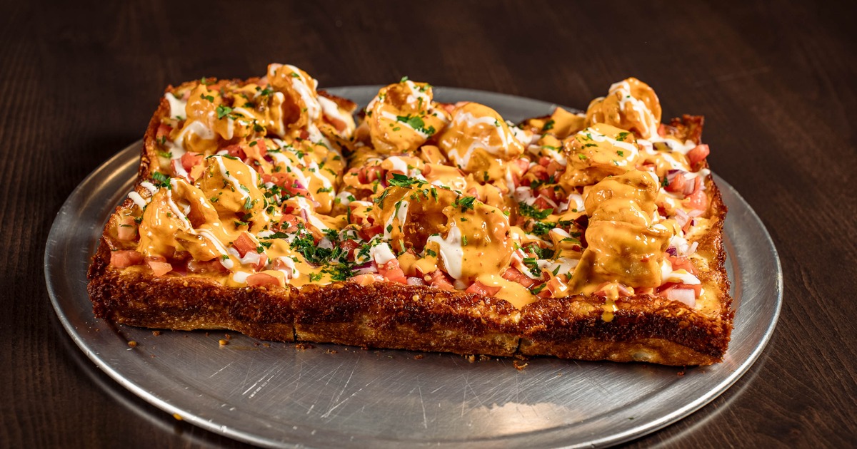 Boom Boom Shrimp Pizza topped with drizzle of sauces and fresh herbs
