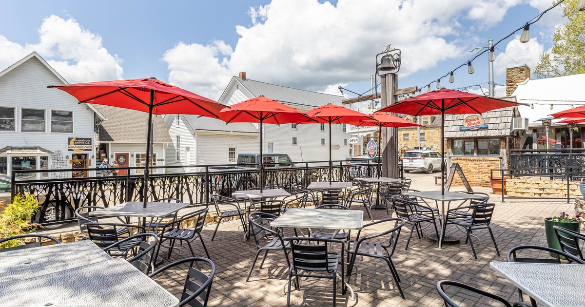 Exterior, patio, partially covered seating area, tables and chairs under red parasols