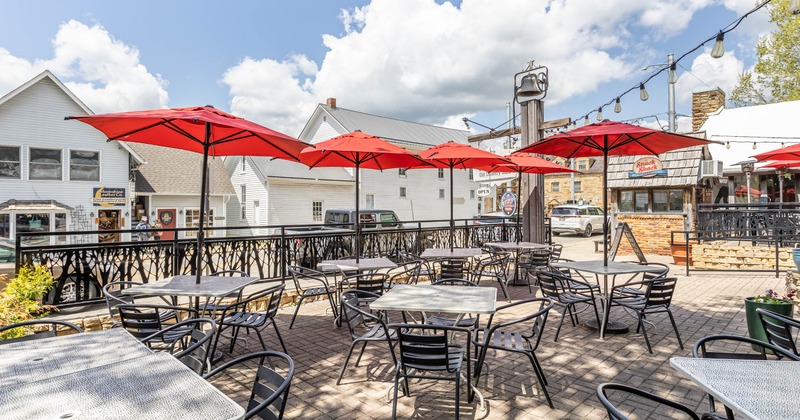 Exterior, patio, partially covered seating area, tables and chairs under red parasols