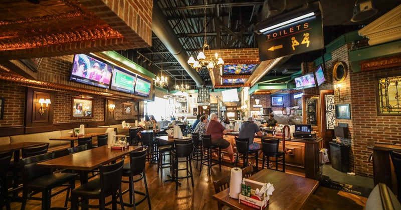 Interior, tables with barstools, the bar on the right