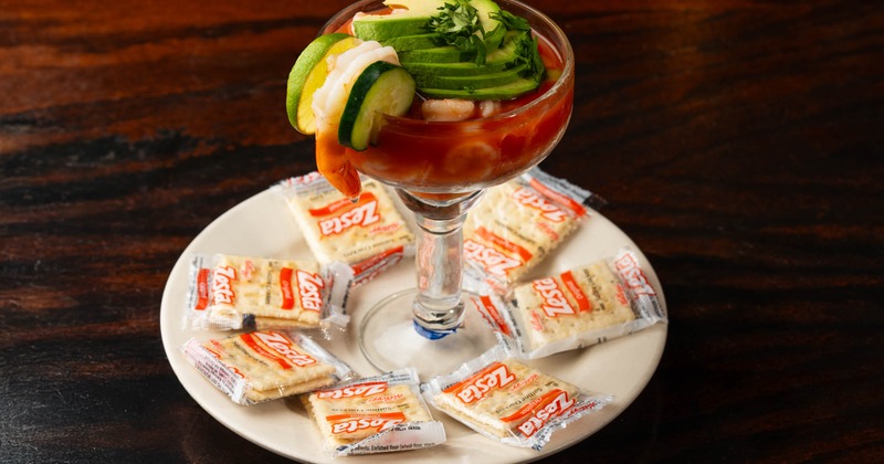 Shrimp Cocktail topped with avocado slices and served with crackers
