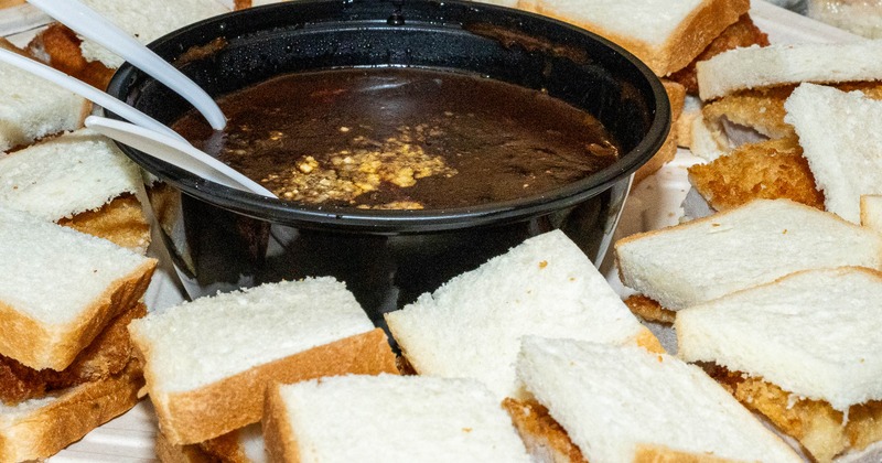Sandwich pieces surrounding a bowl of dipping sauce