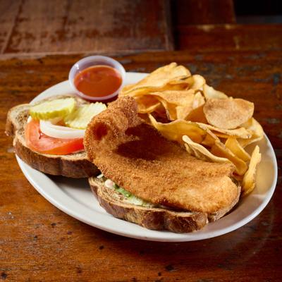 Groupe filet on toasted marble rye with lettuce, tomato, tartar sauce, onion, and pickle.