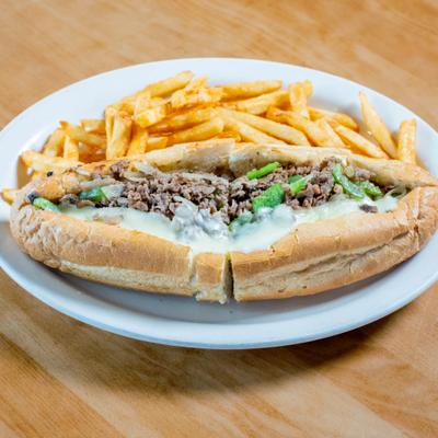 Philly cheesesteak sandwich served with french fries.