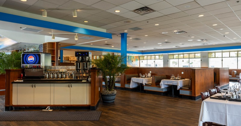 Restaurant dining area with booths, tables, and a beverage station