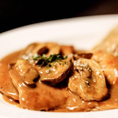 Veal Marsala topped with mushroom sauce, close-up.