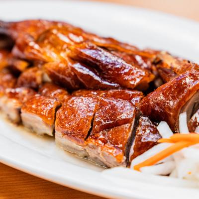 Roasted duck pieces beside pickled vegetables.