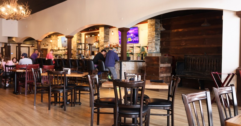 Interior, seating area with wooden tables and chairs, chandeliers