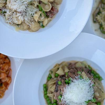 Plates of pasta topped with grated cheese.
