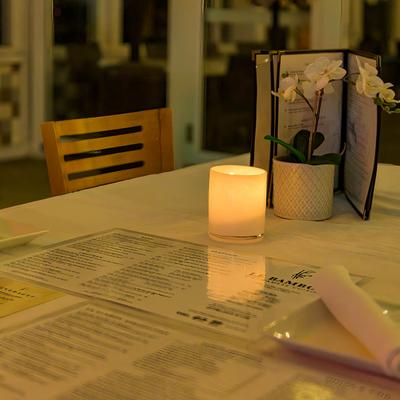 A closeup on a table with a lit candle.