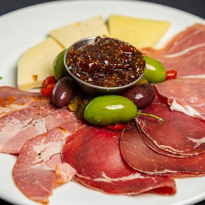 Cold cuts and cheeses, with peppers, olives, and fig jam.