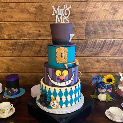 Blue cake decorated with Alice in Wonderland motifs