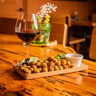 Fried olives plate and red wine on a table