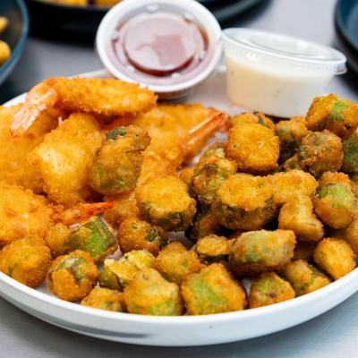 A plate of fried shrimp and okra, served with two dipping sauces.