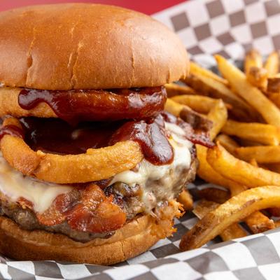 Bacon cheeseburger with BBQ sauce, onion rings, and fries.