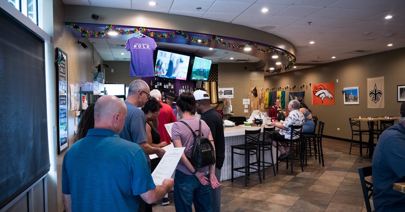 Interior, bar, people, screen above