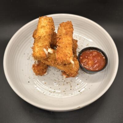 Mozzarella sticks piled on a white plate with a tomato sauce cup on the side.
