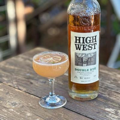 Orange cocktail with lime, and a bottle of whiskey.