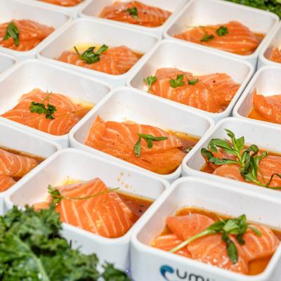 Portions of sliced salmon sashimi arranged in individual containers.