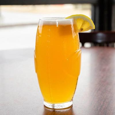 A glass of beer with a lemon wedge.