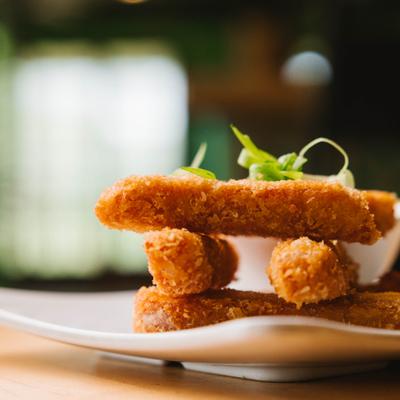 Spam fries stacked on plate with garnish.
