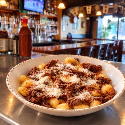 Gnocchi topped with meat sauce and grated cheese on the pub counter..