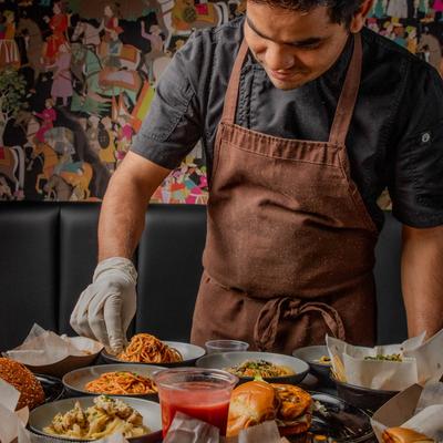 An employee arranging food on a table with assorted dishes.