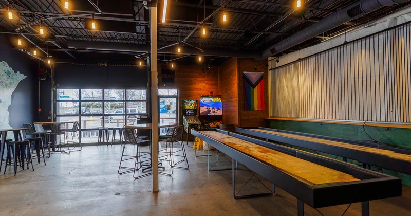 Interior, high seating area, bar tables and stools, two shuffleboards on the right